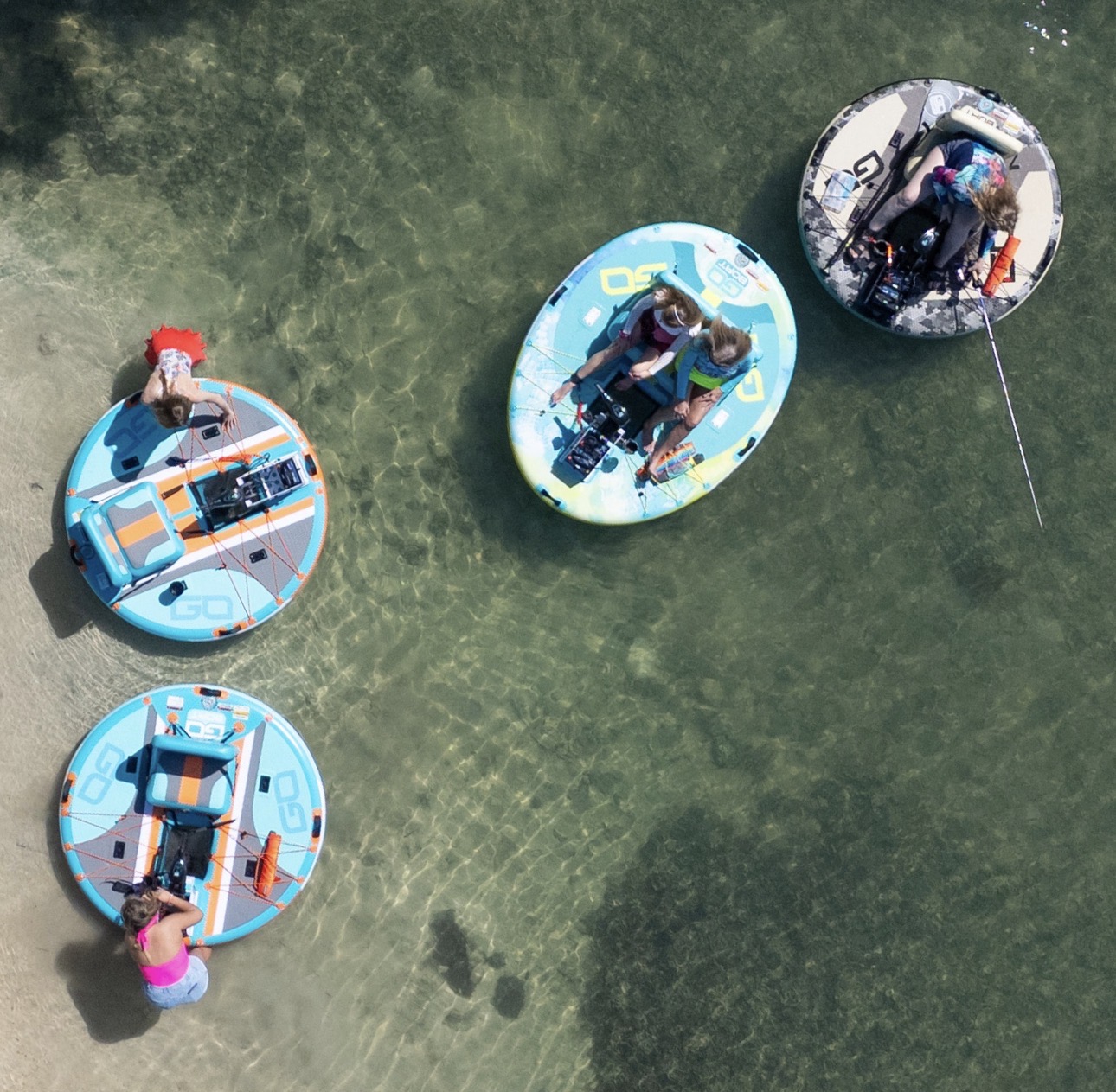 A bird's-eye view of GoBoats anchored in clear, shallow sandbar water beside a white sand shoreline