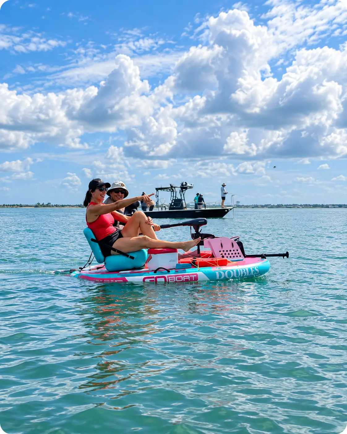 Two friends laughing and pointing the way while riding a pink and teal Double GoBoat on sparkling water